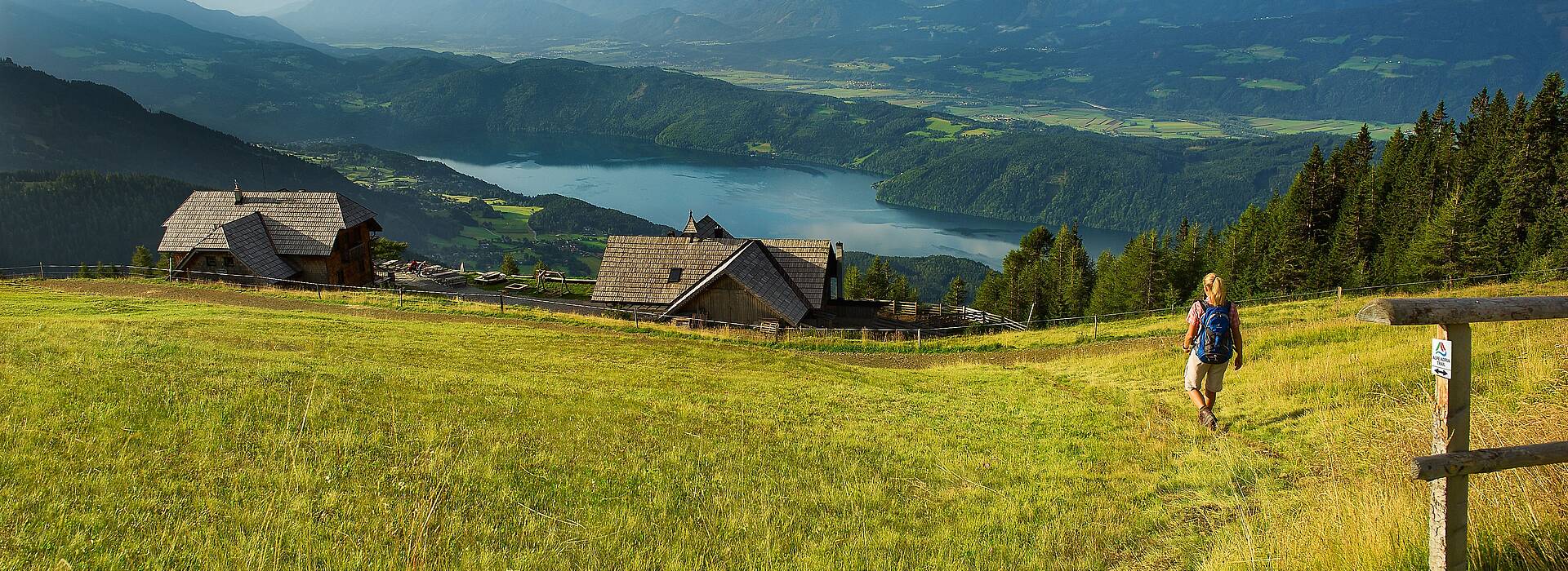 Wanderer auf dem Alpe Adria Trail mit Blick auf See