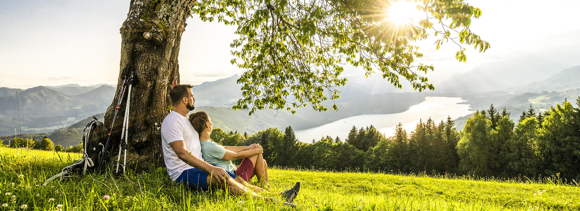 Mann und Frau sitzen im Schatten eines Baumes in der Via Paradiso.