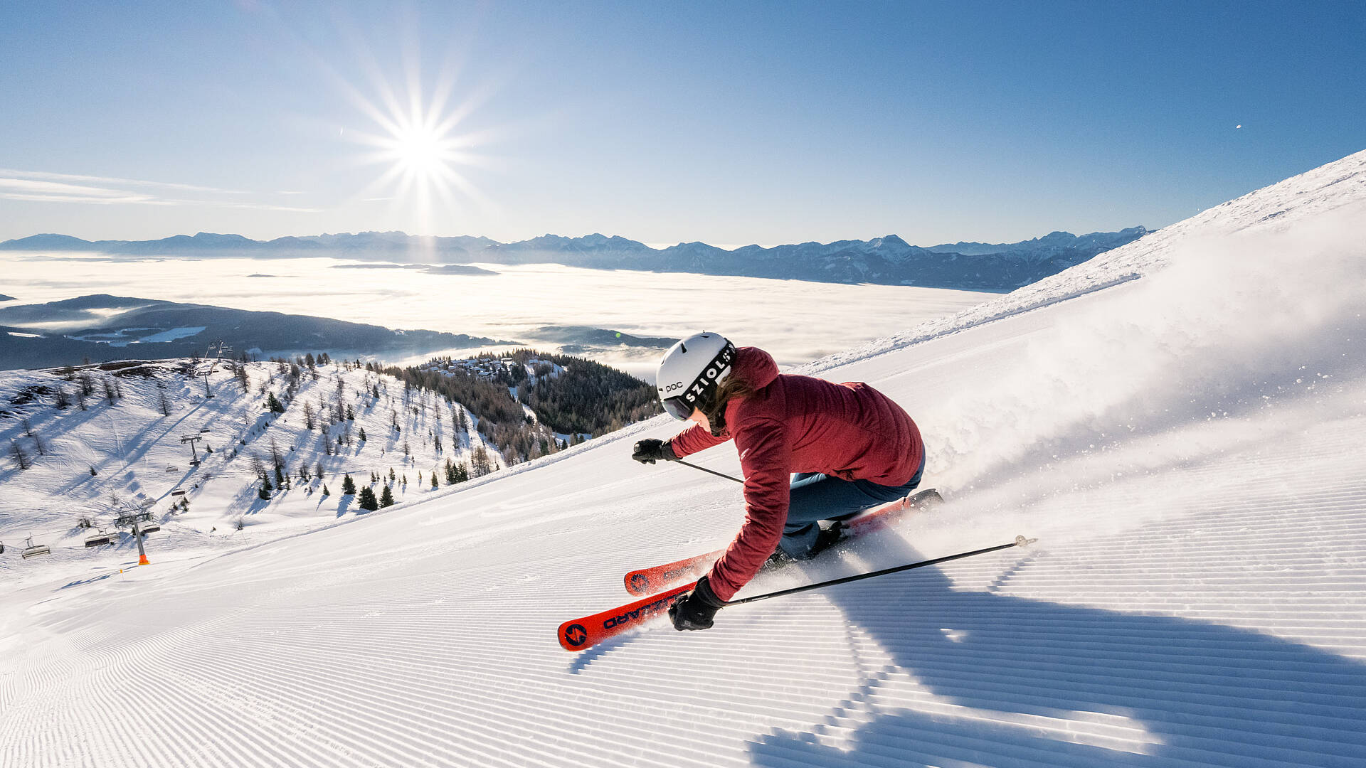 Frau im Roten Anorak beim Skifahren in der Region Villach auf der Gerlitzen