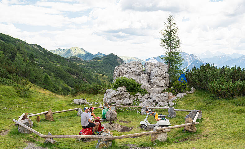 Ein Papa, eine Mama und ihre zwei Kinder machen eine Pause während ihrer Familienwanderung in der Region Nassfeld-Pressegger See