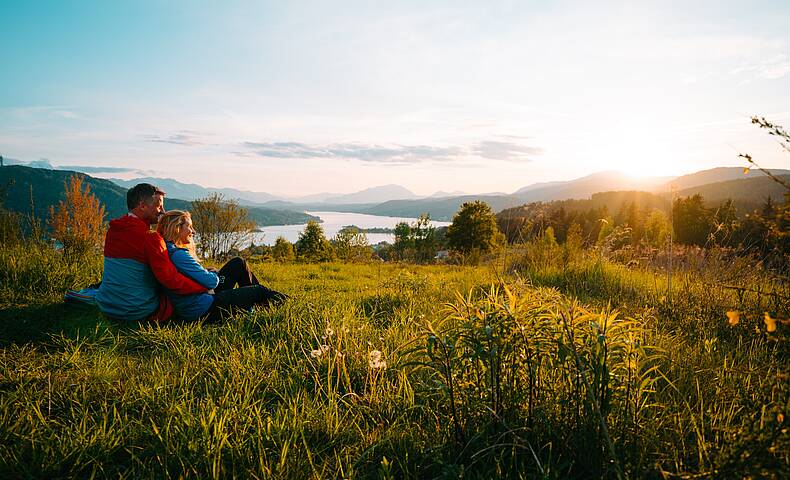 Eine Frau und ein Mann sitzen und machen eine Pause beim Wandern auf dem Wowrthersee-Rundwanderweg am Pirkerkogel.