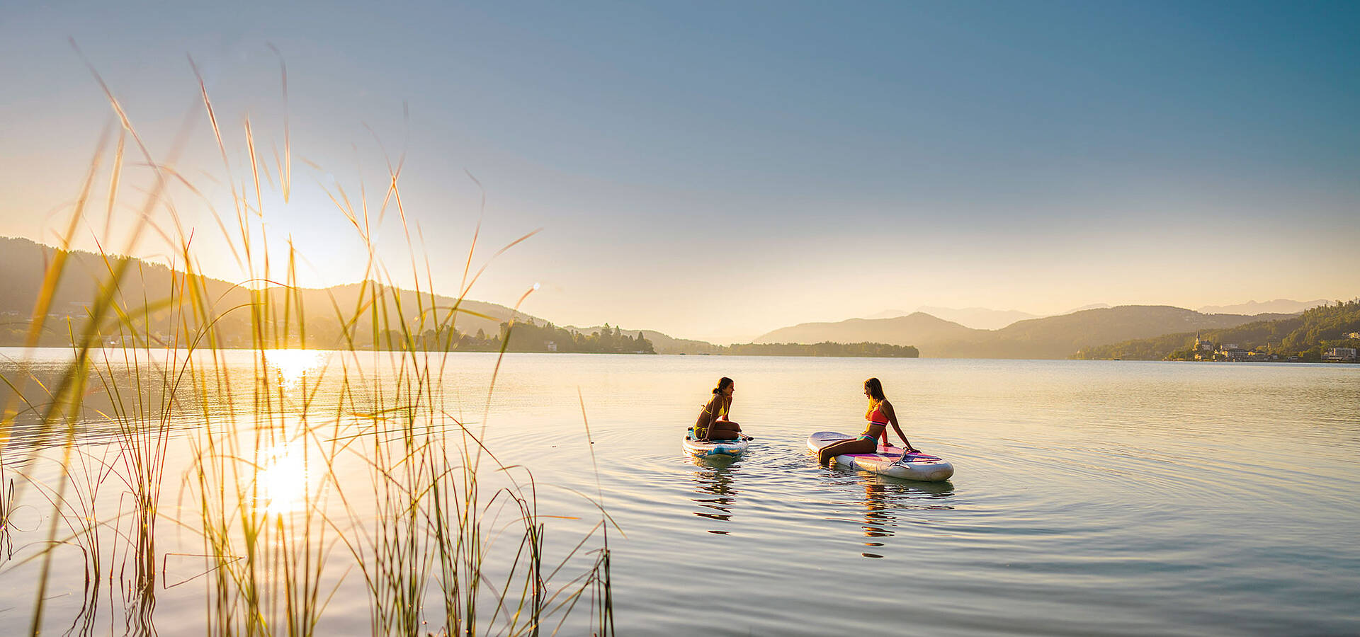Zwei Damen am SUP am Woerthersee bei Sonnenuntergang