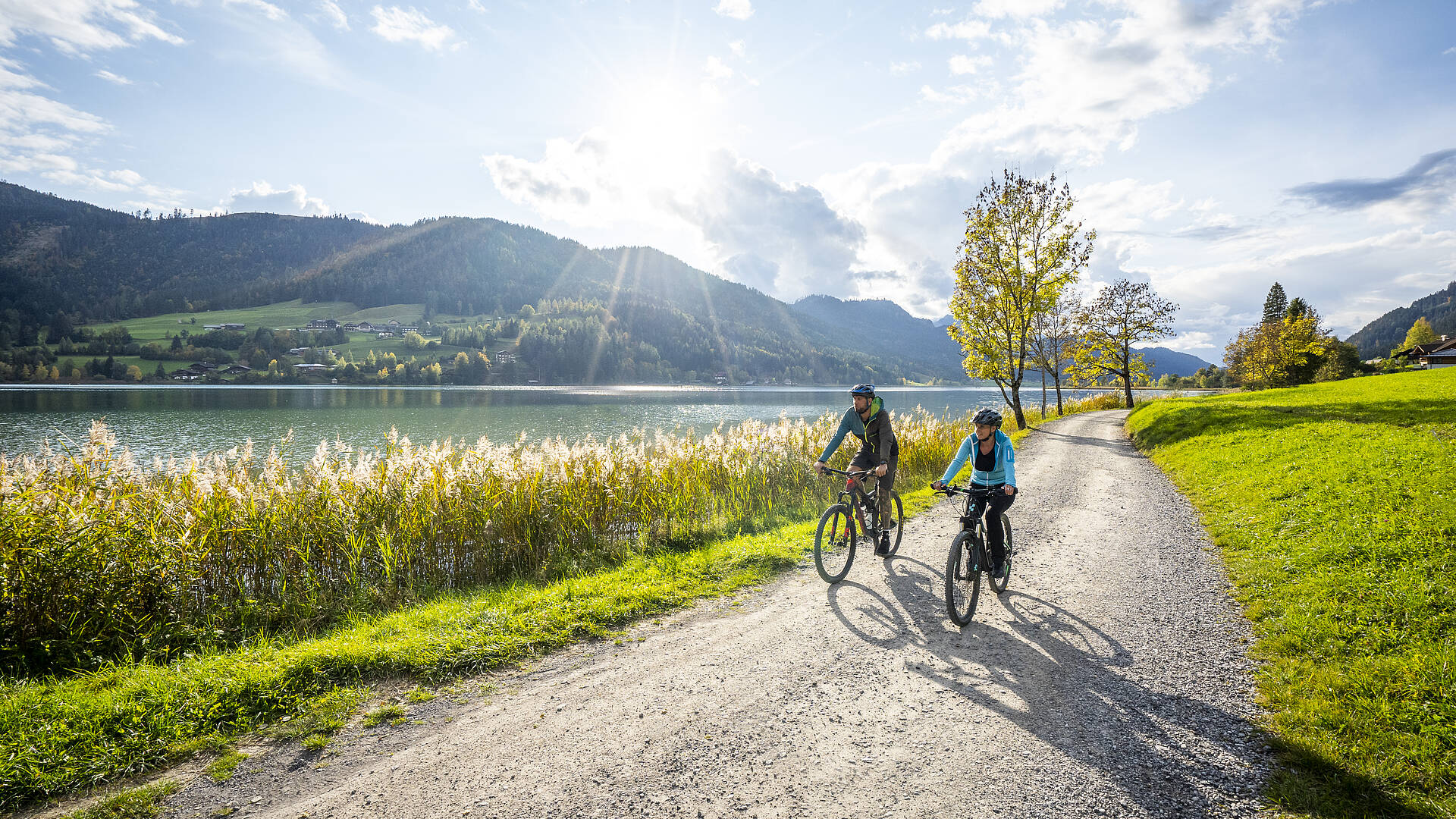 Frau und Mann beim Radfahren im Herbst am schönen Weissensee